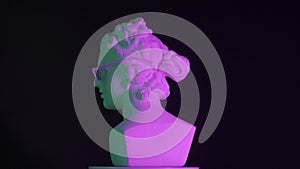 Closeup shot. Ancient marble bust statue of roman era woman in glasses spinning round on a platform in purple light