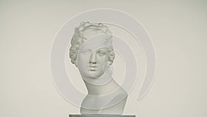 Closeup shot. Ancient marble bust statue of roman era woman spinning round on a platform. Isolated on white background.