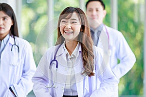 Closeup shot of Asian young cheerful happy professional intern practitioner doctor in white lab coat with stethoscope standing