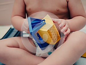 Closeup shot of a baby playing with a plastic toy