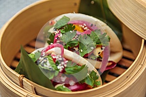 Closeup shot of baos served traditionally in a bamboo basket-good idea for shanghai cuisine ad photo