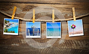 Closeup shot of beach photos hanging from a rope with wooden background