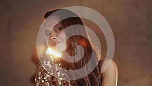 Closeup shot of beautiful actress, elegant woman in golden dress standing posing for photoshoot, flashlights everywhere.