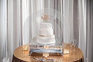 Closeup shot of a beautiful white wedding cake with an H-shaped topping