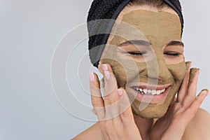 Closeup shot of beautiful young happy woman doing beauty treatment on her face skin. Attractive female smiling with toothy healthy