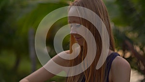 Closeup shot of a beautiful young woman applying an antimosquito repellent spray on her skin. A tropical background