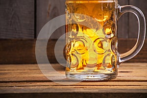 Closeup shot of a big mug of beer on a wooden table