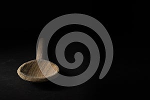 Closeup shot of a big wooden spoon isolated on black background