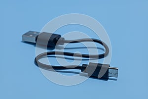 Closeup shot of a black charging micro USB cable against the black background