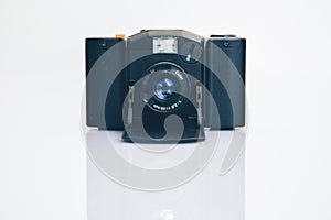 Closeup shot of a black mirrorless interchangeable-lens camera on a white surface