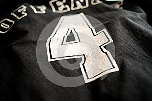 Closeup shot of a black t-shirt with number 4 on the back