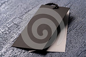 Closeup shot of a blank black clothing tag on a string for a price label on a cloth