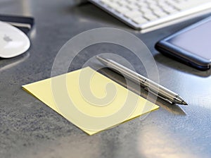 closeup shot of blank yellow sticky note with a pen on office desk