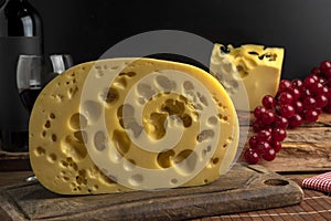 Closeup shot of a block of gourmet swiss cheese on a wooden board