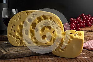 Closeup shot of a block of gourmet swiss cheese on a wooden board