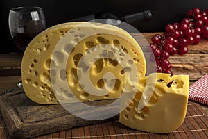Closeup shot of a block of gourmet swiss cheese on a wooden board