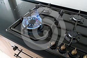 Closeup shot of blue fire from domestic kitchen hob. Gas cooker with burning flames propane gas.