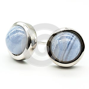 Closeup shot of blue lace agate ear studs behind a white background