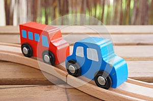 Closeup shot of blue wooden toy car red wooden toy bus on a wooden track