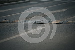 Closeup shot of a bolted down traffic safety speed bump on an asphalt road