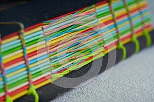 Closeup shot of a book with colorful paper bound with woven thread
