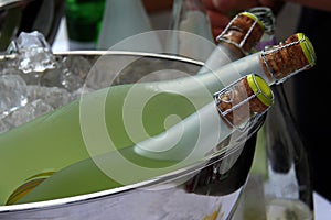 Closeup shot of bottles of drinks in a bucket full of ice