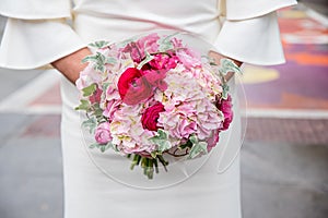 Closeup shot of the bride holding her elegant wedding bouquet with pink and white flowers