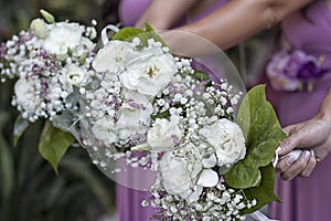 Closeup shot of bridesmaids bouquets: white roses with small flowers and leaves