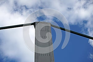 Closeup shot of a bridge with a spike and steel cables under the cloudy sky in a daytime