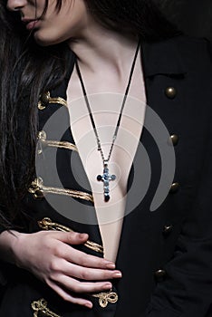 Closeup shot of a brunette woman with a christian symbolic necklace on her neck.