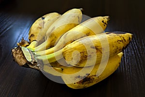 Closeup shot of a bunch of ripe bananas on a dark surface