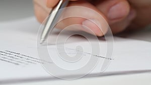 Closeup shot of a business man signing a contract, legal agreement or paper. Man is approve documents by signing papers.