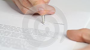 Closeup shot of a business man signing a contract, legal agreement or paper. Man is approve documents by signing papers.