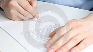 Closeup shot of a business man signing a contract, legal agreement or paper. Man is approve documents by signing papers.