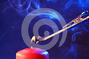 Closeup shot of a candle and burning match
