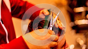 Closeup shot of a Caucasian barber cutting his client& x27;s hair.