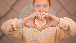 Closeup shot of a caucasian female forming a heart sign with her hands
