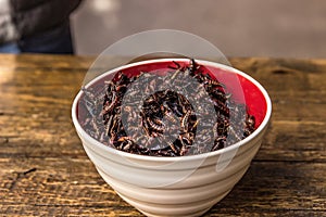 Closeup shot of chapulines in a bowl on a wooden table