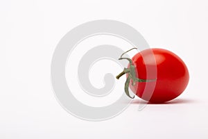 Closeup shot of a cherry tomato on a white background - perfect for a food blog