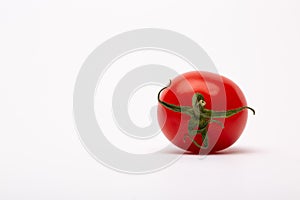 Closeup shot of a cherry tomato on a white background - perfect for a food blog