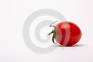 Closeup shot of a cherry tomato on a white background - perfect for a food blog