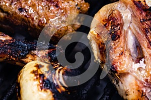 Closeup shot of chicken steak grilled and meat rolls on a charcoal barbeque