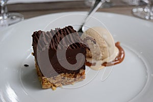 Closeup shot of a chocolaty delicious cake with ice cream on a white plate