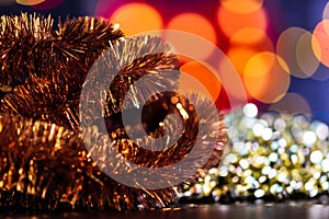 Closeup shot of a Christmas background with tinsel and ornaments on a bokeh background