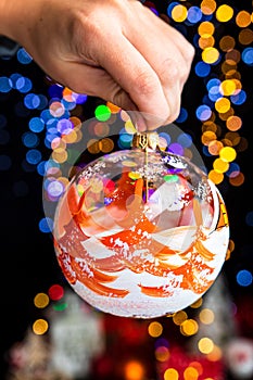 Closeup shot of a Christmas tree ornament with blurred lights in the background