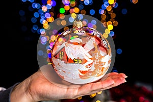 Closeup shot of a Christmas tree ornament with blurred lights in the background