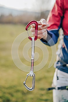 Closeup shot of a climber holding in a hand a quickdraw