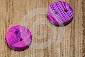 Closeup shot of colorful buttons put on a wooden surface