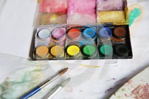 Closeup shot of a colorful painting kit and some brushes