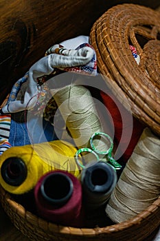 Closeup shot of colorful yarn rolls in a woven basket